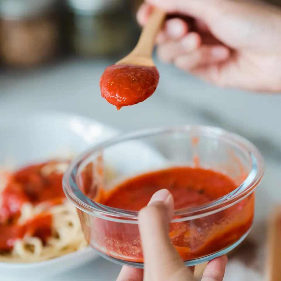 Sirviendo salsa de tomate en cuchara de madera